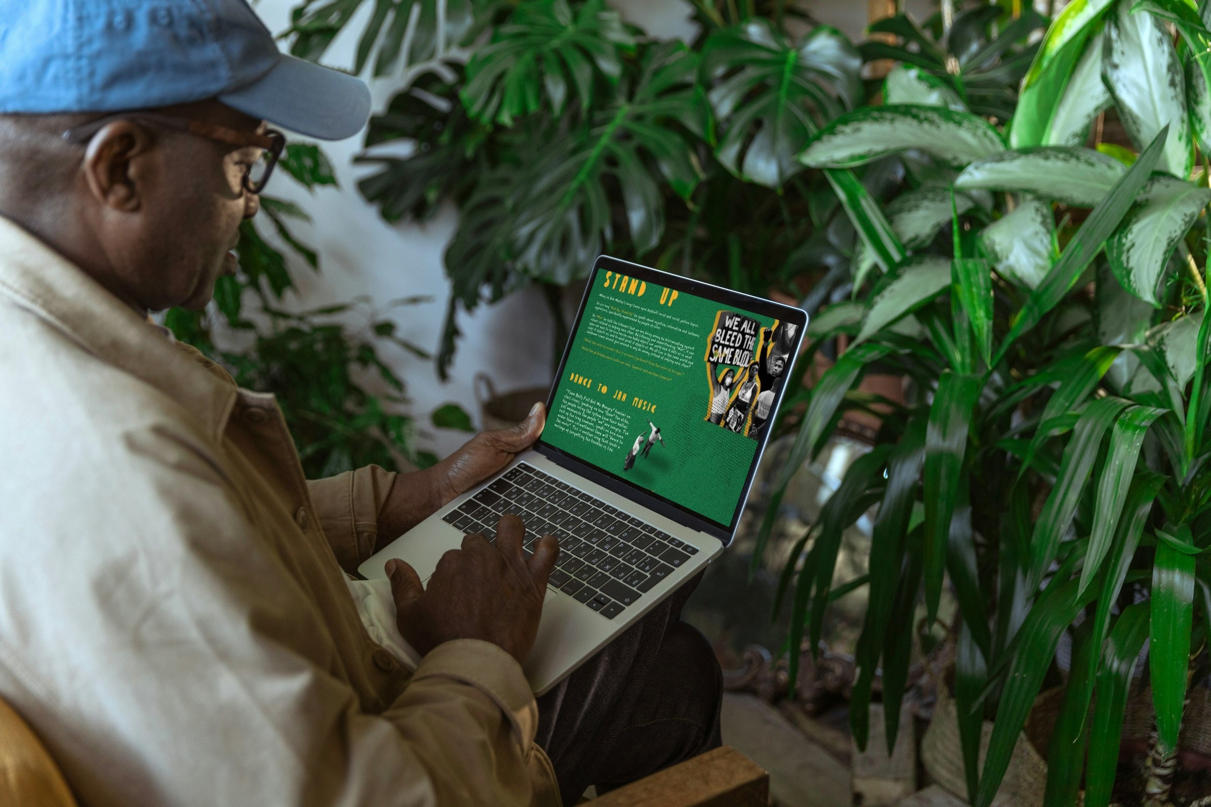 Man in a cap browsing the Stand Up page of the tribute site on a laptop