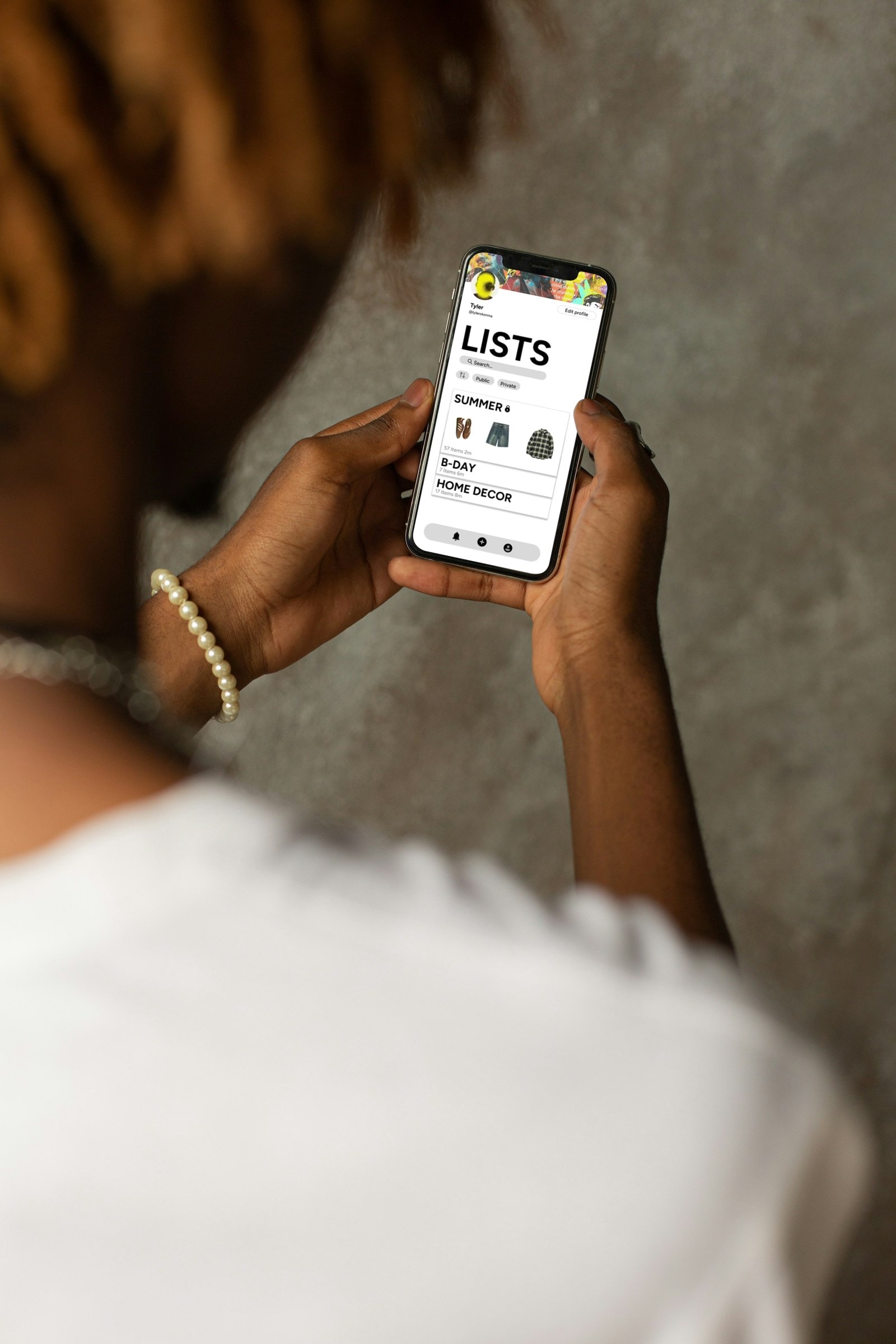 Hands holding a phone showing the Lists screen of the Boroughs app