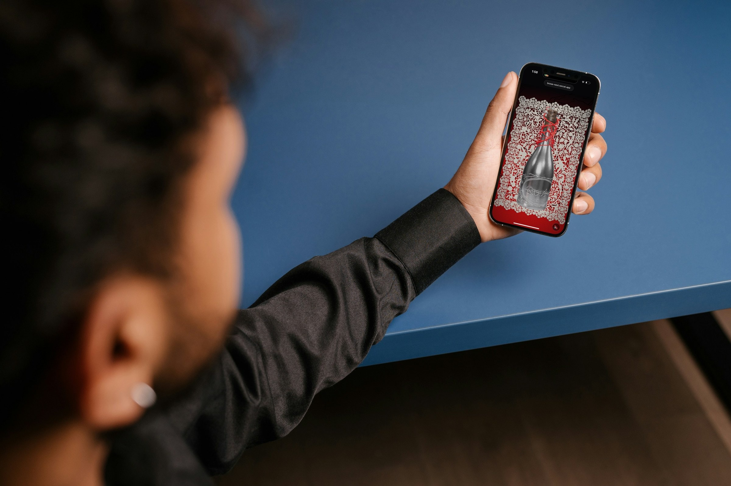 Man holding up his phone showing the Brosé bottle page