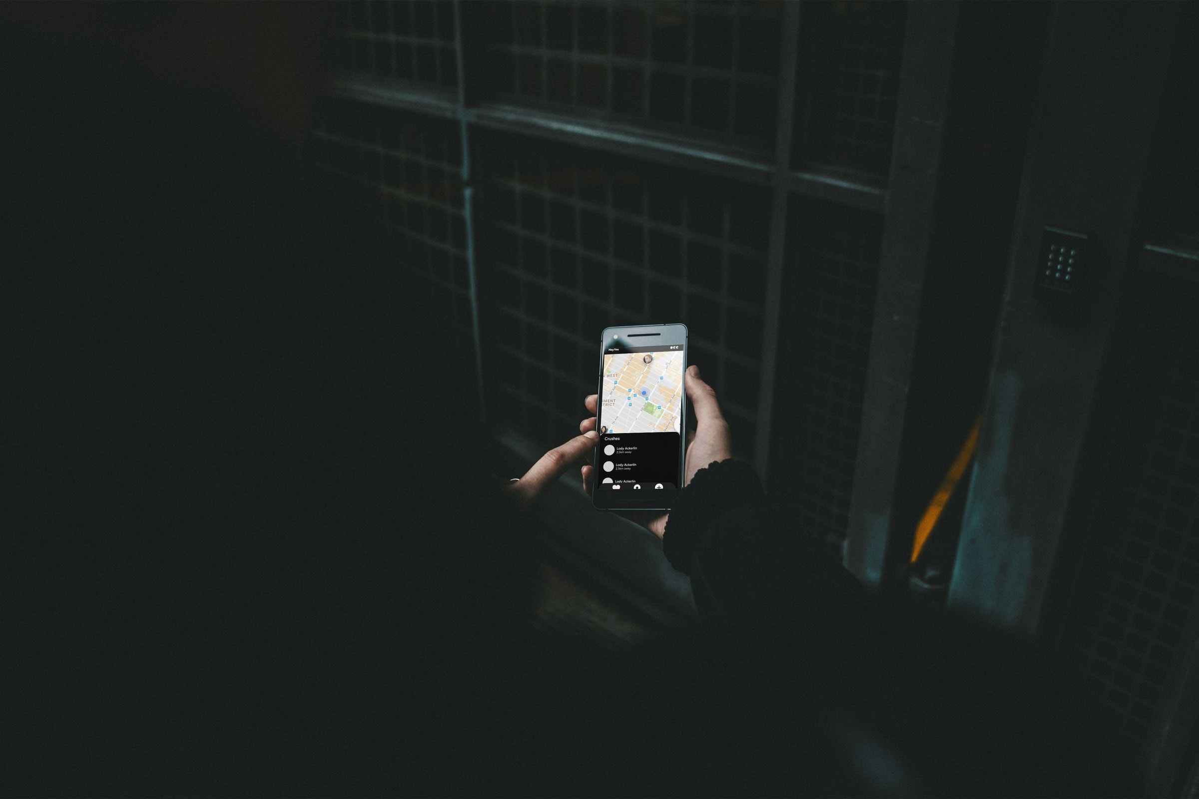 Phone glowing in the dark showing a map of nearby crushes