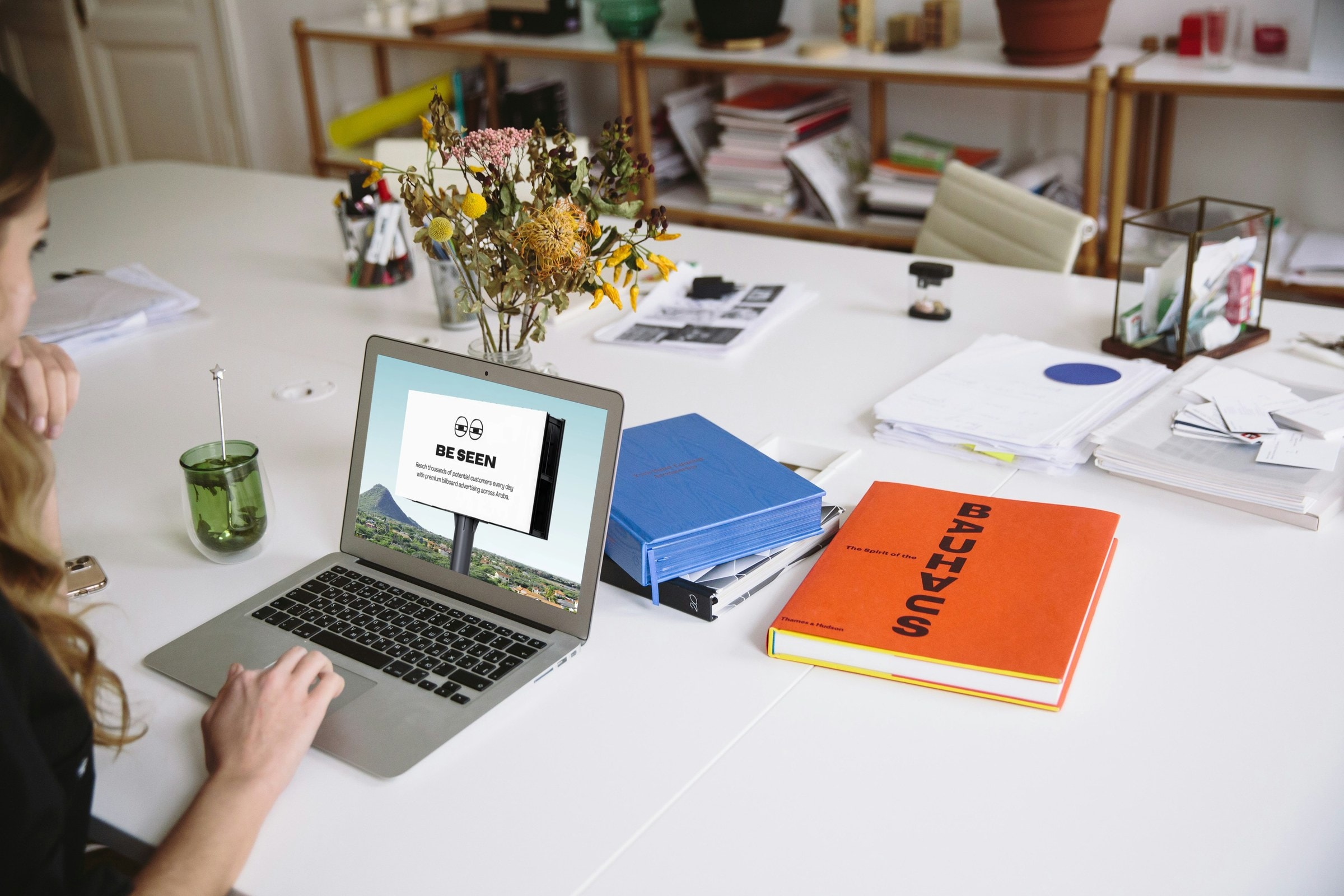 Laptop on a desk showing the Be Seen billboard newsletter