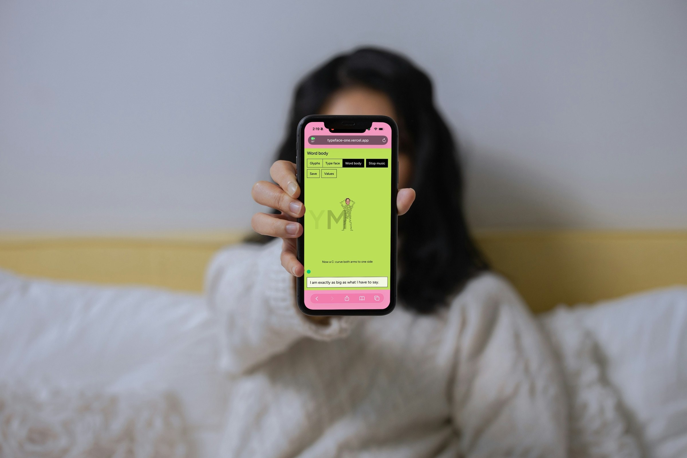Person holding a phone up to the camera showing the Word Body screen