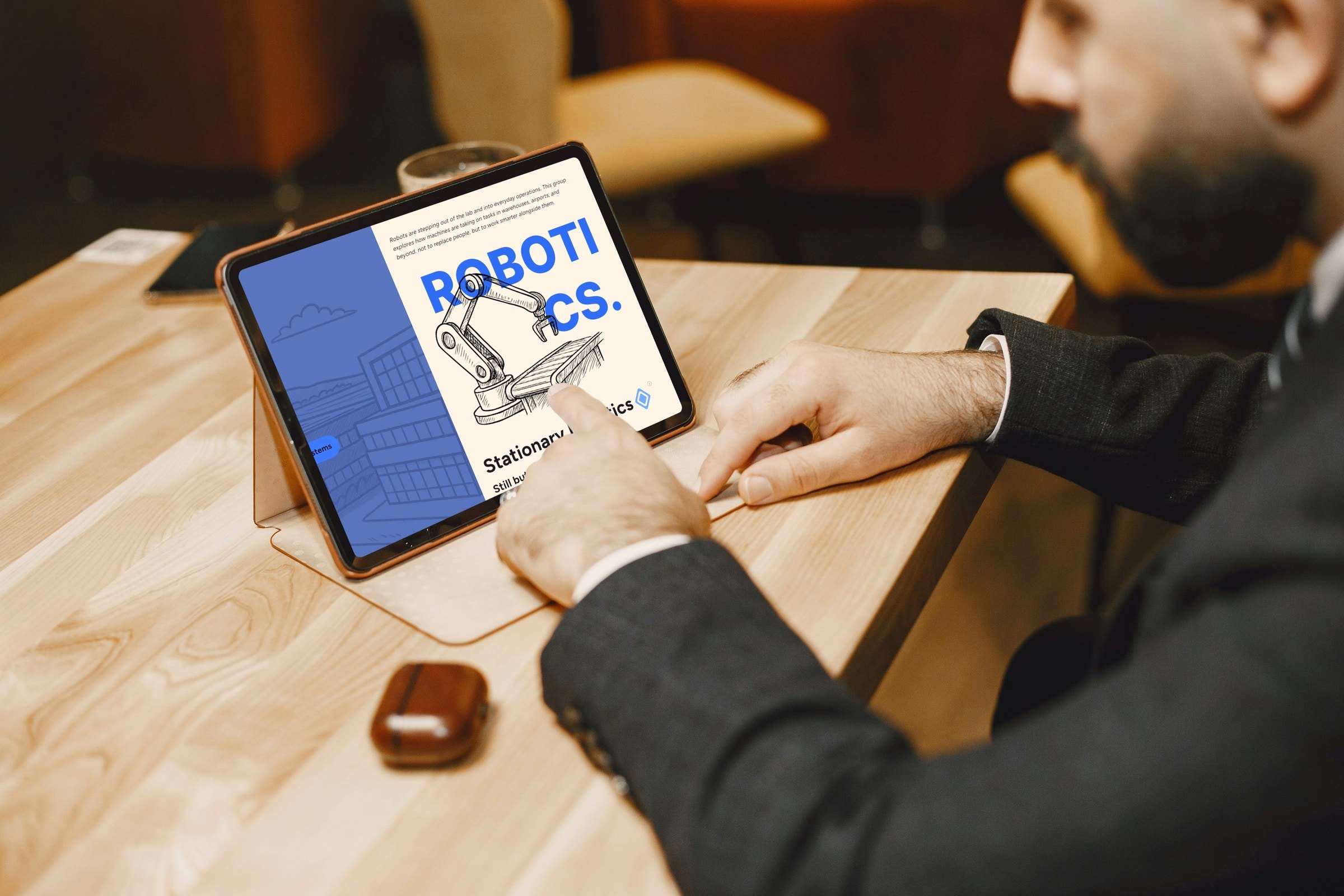 Man tapping the Robotics chapter of the trend report on a tablet
